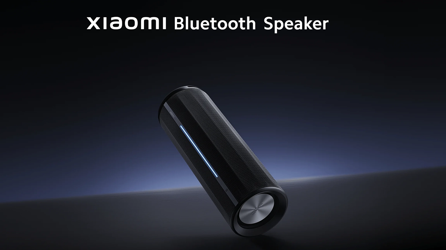 A sleek black Xiaomi Bluetooth speaker with a cylindrical design and a blue LED light, set against a dark background.